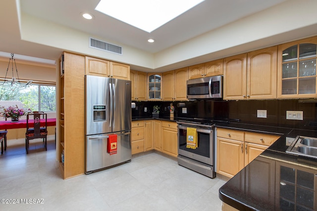 kitchen with pendant lighting, a chandelier, backsplash, and appliances with stainless steel finishes