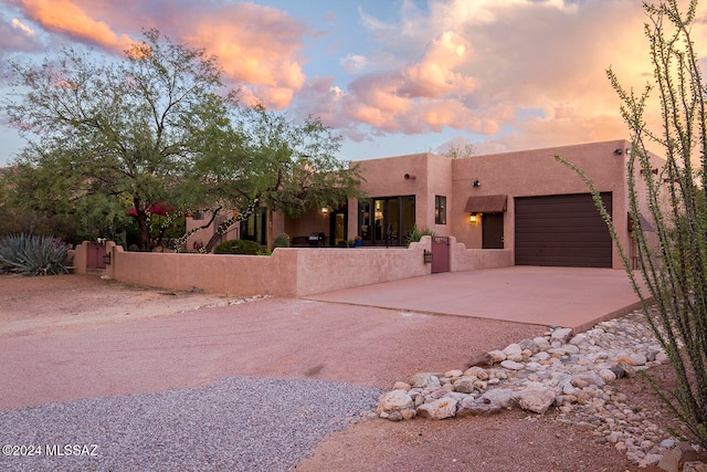 pueblo revival-style home with a garage