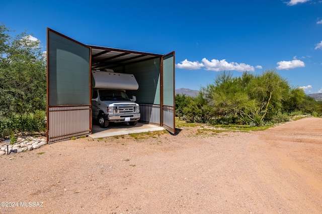 view of parking / parking lot with a mountain view and a carport