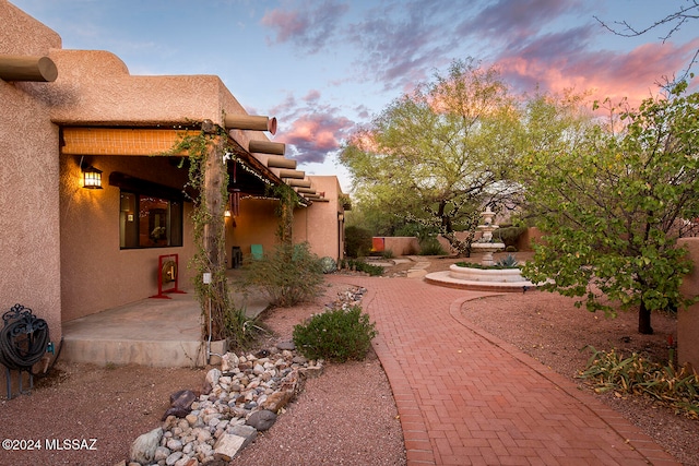 yard at dusk featuring a patio