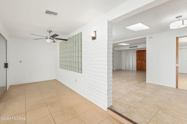 tiled spare room featuring ceiling fan and a textured ceiling