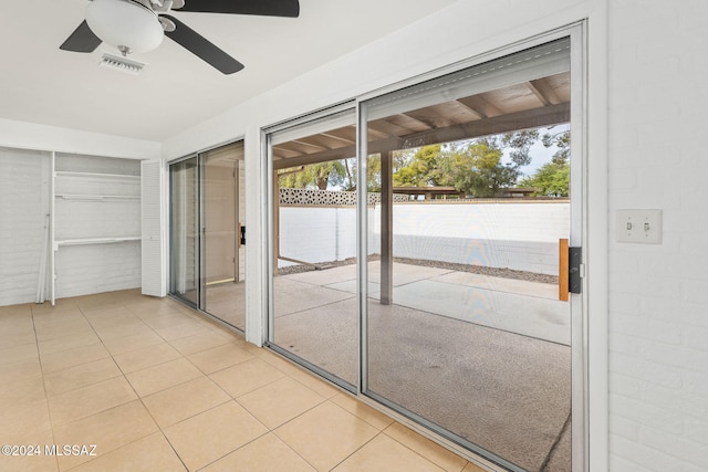 doorway to outside featuring ceiling fan and light tile patterned floors