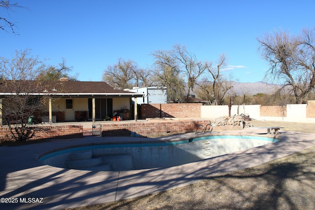 view of swimming pool with a mountain view and a patio