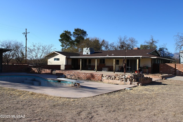 rear view of house featuring a patio area and a fenced in pool