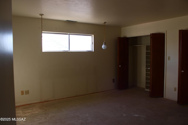 unfurnished bedroom with concrete flooring