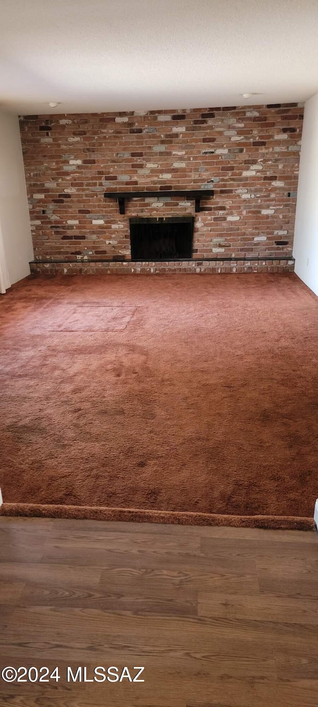 unfurnished living room featuring a fireplace and dark hardwood / wood-style floors