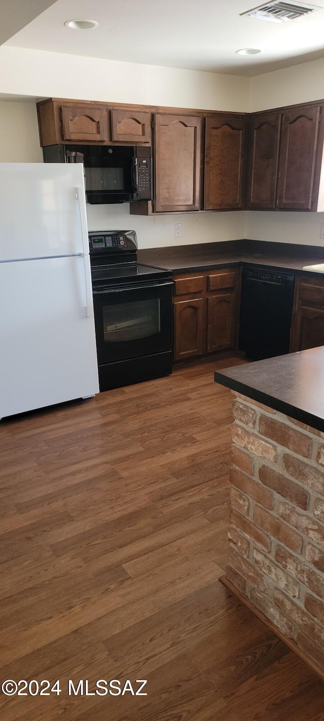 kitchen featuring black appliances, dark hardwood / wood-style flooring, sink, and dark brown cabinetry