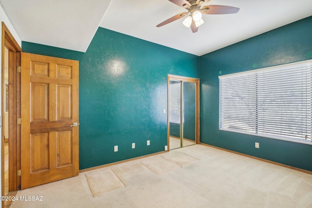 unfurnished bedroom with ceiling fan, a closet, and carpet