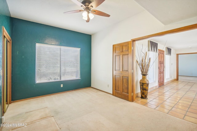 spare room with ceiling fan and tile patterned floors