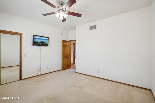 carpeted spare room featuring ceiling fan