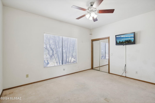 unfurnished bedroom featuring light colored carpet and ceiling fan