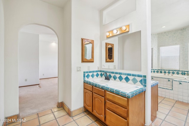 bathroom with vanity, a tub, and tile patterned flooring