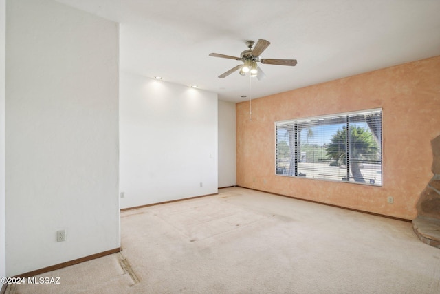 carpeted spare room featuring ceiling fan