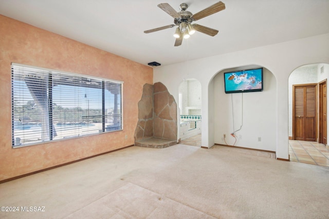 unfurnished room with light colored carpet and ceiling fan