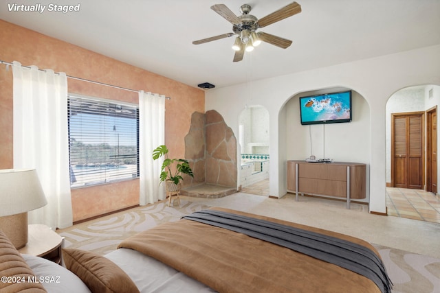 bedroom featuring light tile patterned floors, ceiling fan, and ensuite bathroom