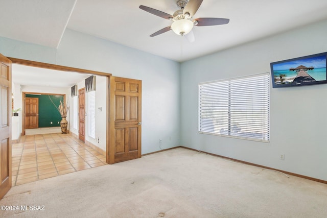 carpeted spare room with ceiling fan