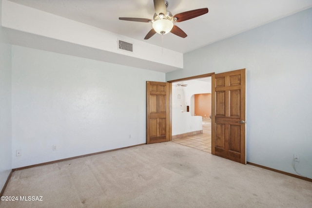 spare room with light colored carpet and ceiling fan