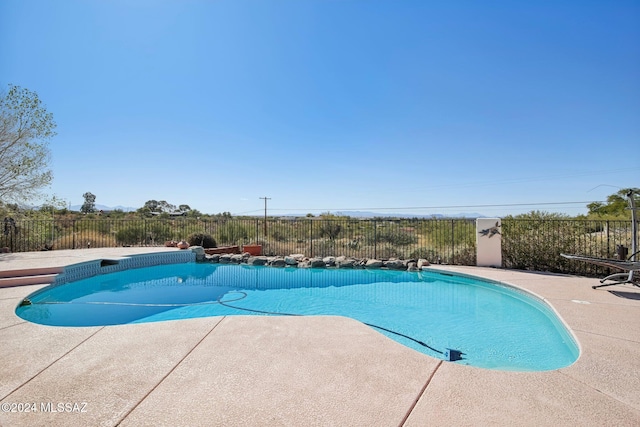 view of swimming pool featuring a diving board and a patio