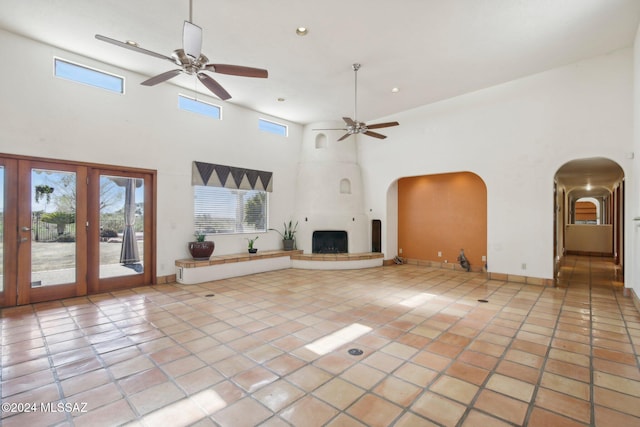 unfurnished living room with a towering ceiling and light tile patterned floors