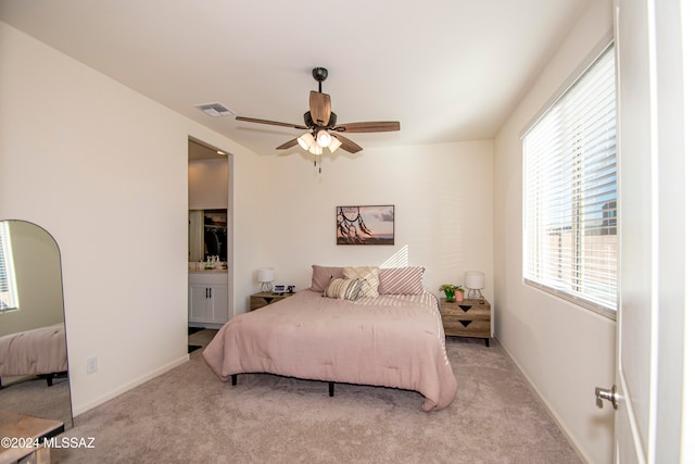 carpeted bedroom featuring baseboards, visible vents, a ceiling fan, and ensuite bathroom