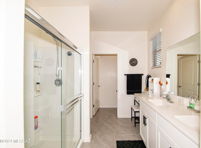 full bathroom featuring double vanity, tile patterned floors, a sink, and a shower stall