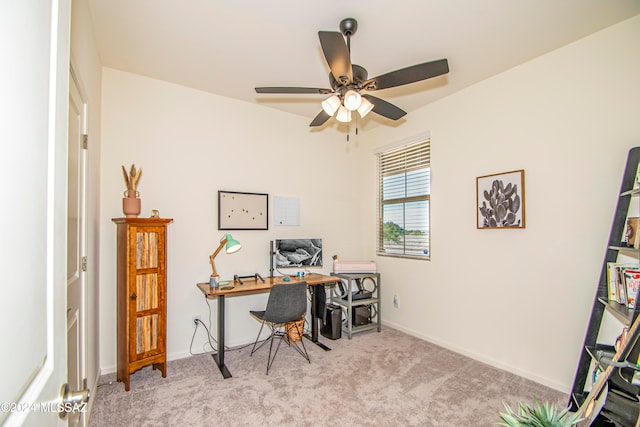 carpeted office space featuring ceiling fan and baseboards