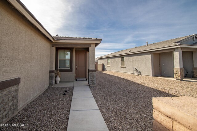 view of exterior entry featuring a patio area