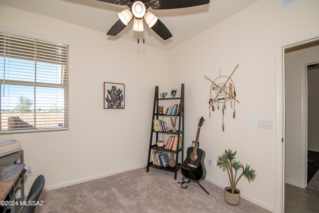 interior space with baseboards, dark colored carpet, and a ceiling fan