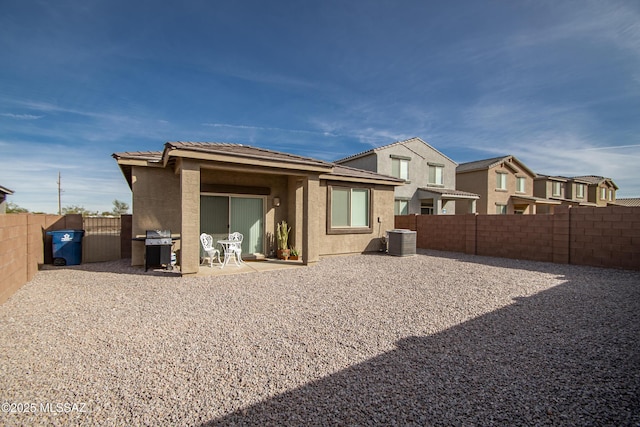 back of house with a patio, central AC unit, a fenced backyard, a tile roof, and stucco siding