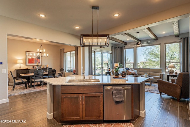 kitchen with plenty of natural light, hanging light fixtures, a center island with sink, and dark hardwood / wood-style flooring