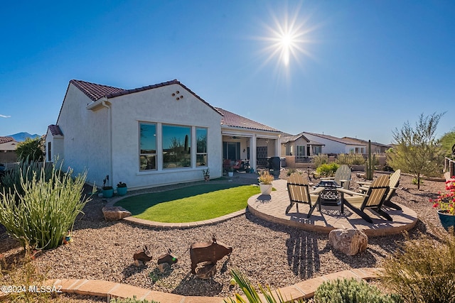 rear view of property with a patio area and a fire pit