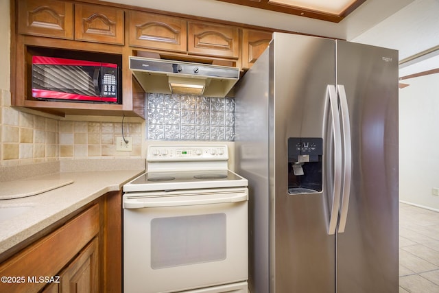 kitchen featuring stainless steel refrigerator with ice dispenser, backsplash, and white range with electric stovetop