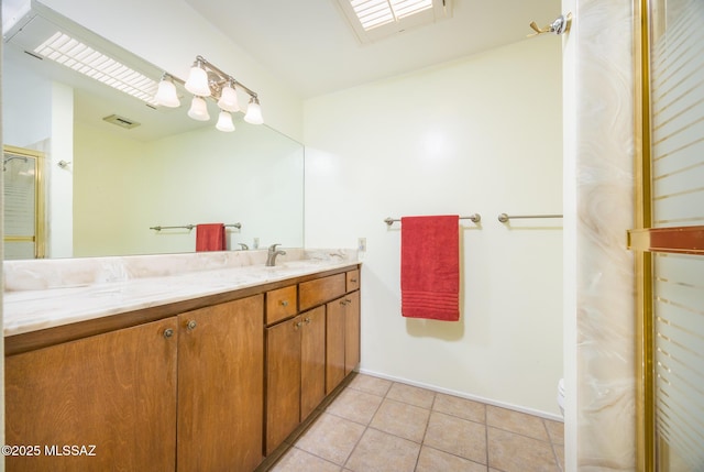 bathroom with a skylight, vanity, an enclosed shower, tile patterned floors, and toilet