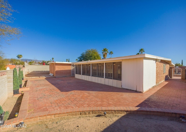 back of house with a sunroom and a patio