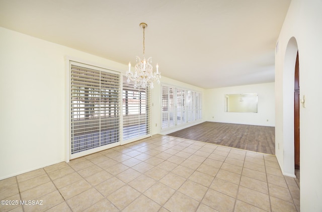 unfurnished dining area with an inviting chandelier and light tile patterned floors