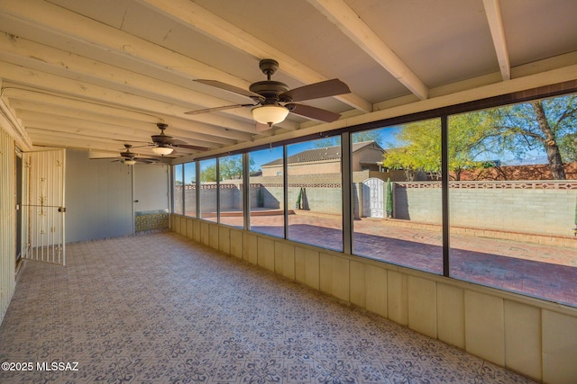 unfurnished sunroom with ceiling fan and beam ceiling