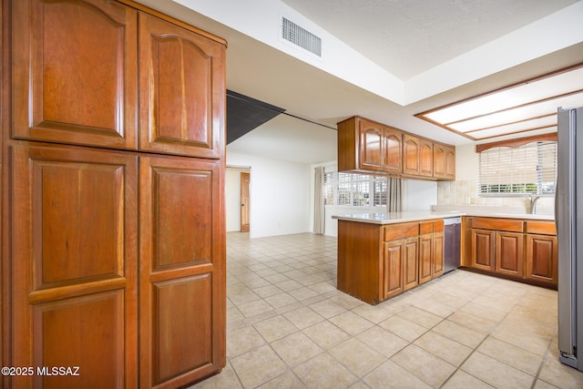 kitchen with light tile patterned flooring, appliances with stainless steel finishes, and kitchen peninsula