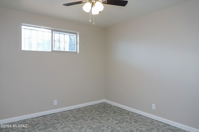 tiled empty room featuring ceiling fan