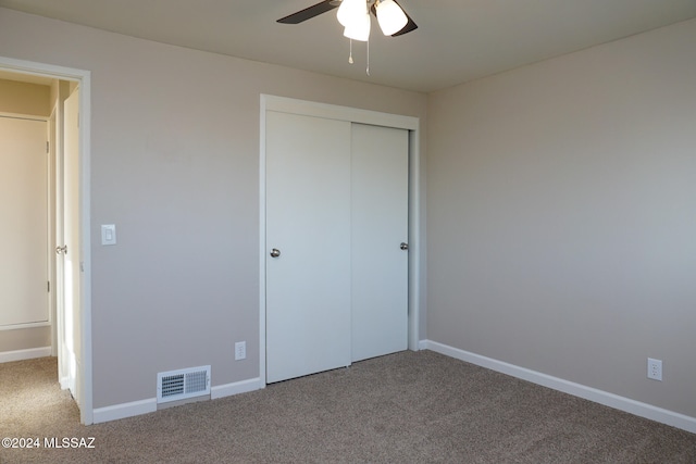 unfurnished bedroom with carpet flooring, ceiling fan, and a closet