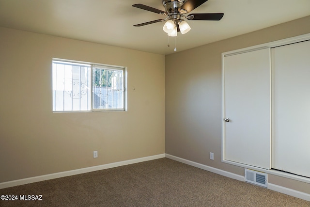 unfurnished bedroom featuring carpet, ceiling fan, and a closet