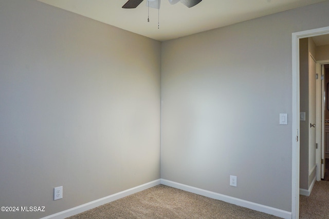 carpeted spare room with ceiling fan