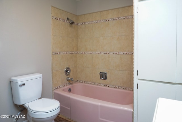 bathroom with toilet and tiled shower / bath combo