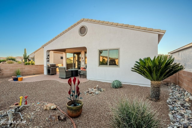 back of house with a fenced backyard, a patio area, and stucco siding