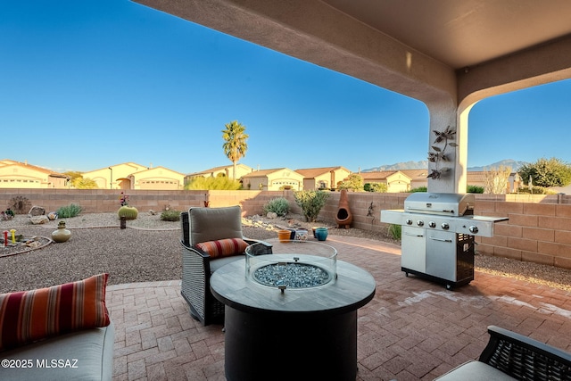 view of patio featuring a fenced backyard, a fire pit, and area for grilling