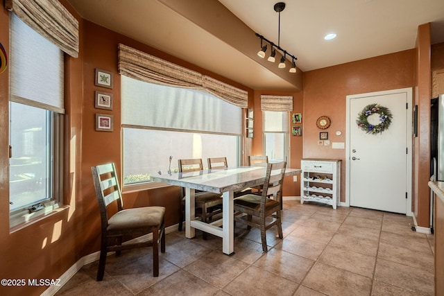 dining area with track lighting, baseboards, and light tile patterned floors