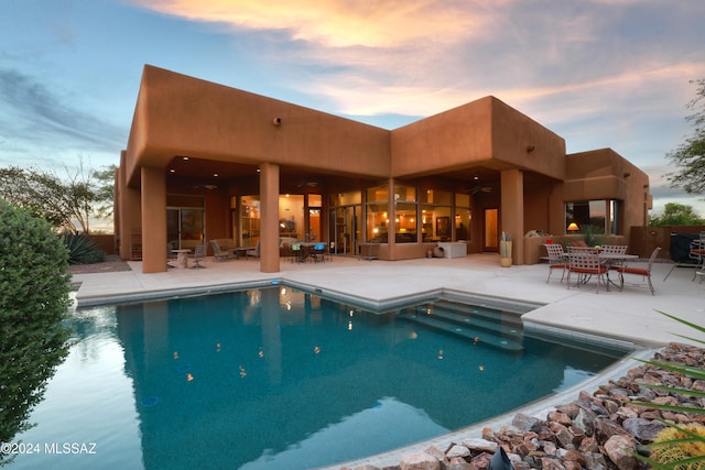 pool featuring ceiling fan, fence, a patio, and outdoor dining space