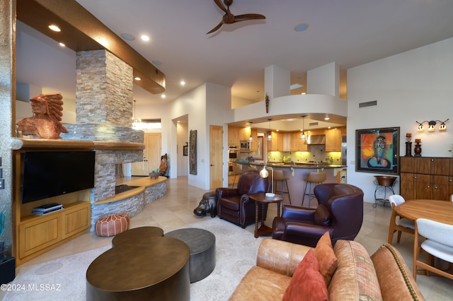 living area featuring recessed lighting, visible vents, ceiling fan, and a towering ceiling