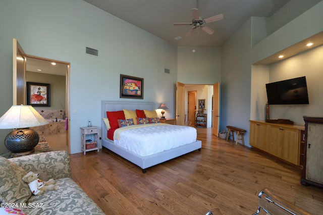 bedroom featuring dark wood-type flooring, ceiling fan, and high vaulted ceiling