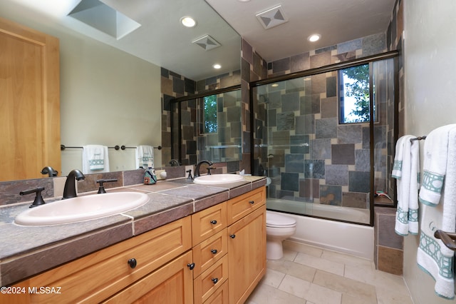 bathroom with enclosed tub / shower combo, visible vents, double vanity, and a sink