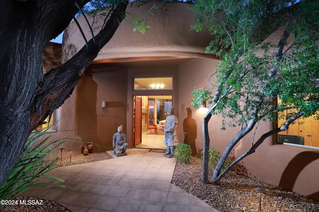 property entrance with a patio and stucco siding
